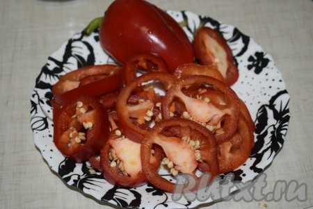 Нарезаем болгарский и острый перец на колечки шириной, примерно, 0,5 см, семена у перцев не удаляем, режем вместе с ними.
