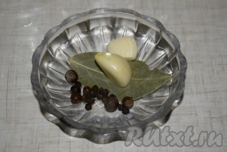 В каждую банку положить чеснок, нарезанный на пластины, и добавить перец горошком, душистый перец, лавровый лист и гвоздику.