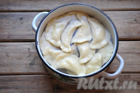 В кастрюлю с кипящей подсоленной водой выложить вареники, аккуратно перемешать, чтобы они не прилипли ко дну. Когда вареники всплывут, проварить их ещё 1-2 минуты. Готовые вареники достать шумовкой из воды, выложить в миску и добавить к ним сливочное масло по вкусу.
