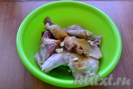 Кролика разделить на части, посыпать специями, добавить нарезанный чеснок.
