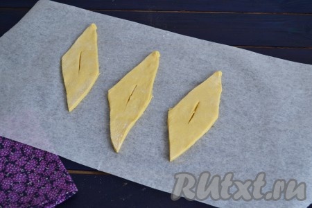 Тесто нарезать на ромбы. Величина их будет зависеть только от Ваших предпочтений, на вкус это не повлияет. В середине каждого ромба прорезать дырочку.
