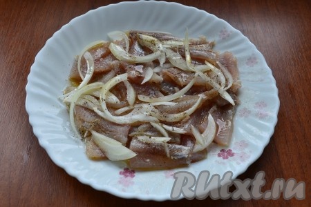 Теперь самое кропотливое - нужно отделить рыбку от всех костей, выкладывая кусочки на тарелку. Рыбу поперчить, сбрызнуть уксусом, полить подсолнечным маслом и посыпать полукольцами репчатого лука. Можно выкладывать рыбу в несколько слоев.