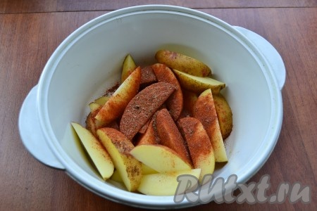 Каждую не очищенную картофелину разрезать на 8 долек, поместить в кастрюлю, предназначенную для приготовления в микроволновке. Всыпать приправу для картофеля (в нее входит и соль).