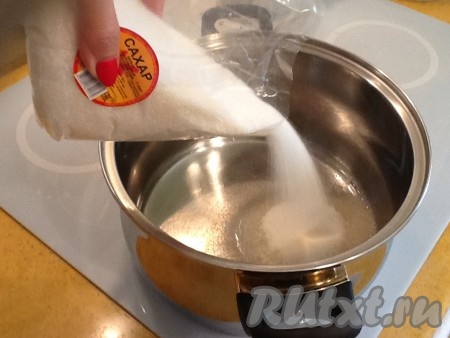 В кастрюлю для варки варенья наливаем воду и добавляем половину сахара, перемешиваем.