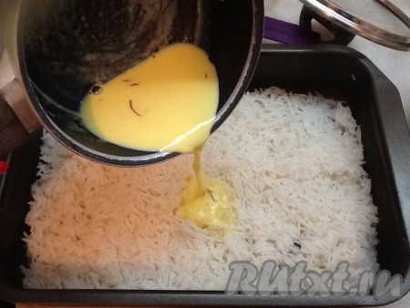 Рис перекладываем на противень и поливаем приготовленным шафрановым молочком. Включаем духовку на разогрев до 180 градусов.
