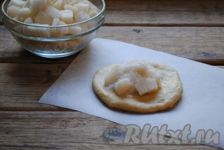 Подошедшее тесто обмять и разделить на 10-12 равных частей. Раскатать каждую часть теста в лепёшку. В центр каждой лепешки выложить нарезанные груши, посыпать 0,5-1 чайной ложкой сахара.&nbsp;
