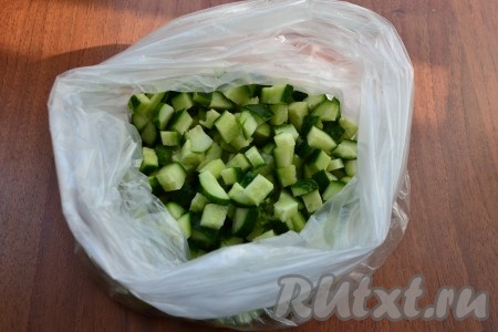 Нарезать огурцы небольшими кубиками, выложить в 2 целлофановых пакета, вложенных один в другой.

