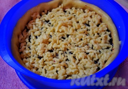 Отложенное ранее тесто достать из морозилки, натереть на крупной тёрке и равномерно распределить поверх черники.