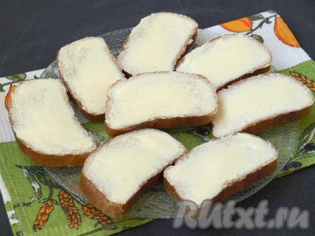 Заранее достать из холодильника сливочное масло, чтобы оно немного размягчилось и его было легко намазывать на хлеб. Смазать маслом ломтики хлеба.