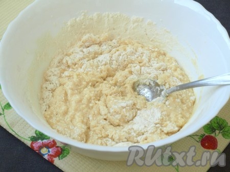 Добавить в смесь яйцо и еле тёплое молоко, ещё раз хорошо размешать. После этого всыпать муку с разрыхлителем и перемешать тесто ложкой.
