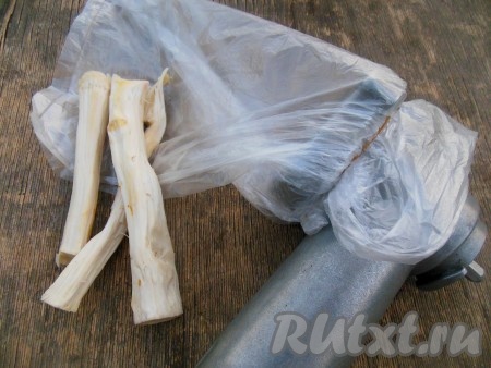 На мясорубку на зажим наденьте пакет и закрепите его резинкой, как на фото, - если этого не сделать, то при выходе из мясорубки перекрученного хрена, у вас будут очень сильно слезиться глаза.
