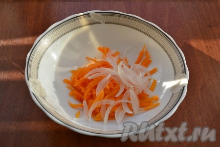 Лук очистить, нарезать тонкими полукольцами и ошпарить кипятком. Мякоть тыквы (сладкие сорта) натереть на крупной терке и добавить нарезанный лук.
