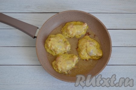 Сковороду разогреть, влить растительное масло. Через минуту выложить куриные крылышки в кляре.
