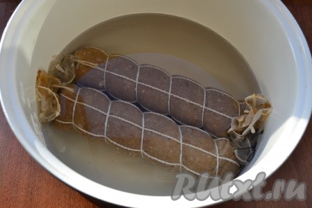 Батоны колбасы подвесить при комнатной температуре на 1 час. Затем отварить колбасу, полностью залив её водой комнатной температуры. Я варила в мультиварке на режиме "Мультиповар" при 80 градусах 1 час 15 минут, закрыв крышку. Также можно отварить колбасу в кастрюле на небольшом огне, не допуская кипения воды, в течение 1 часа 15 минут, прикрыв крышкой.