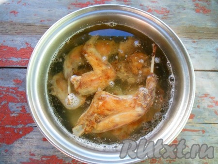 В кастрюлю с кусочками кролика налейте столько горячей воды, чтобы мясо было покрыто водой на 1-2 см, накройте крышкой и тушите на медленном огне около 30 минут.