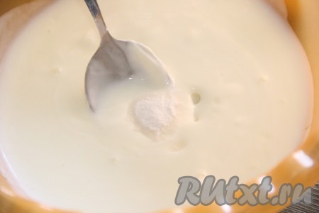 В глубокую миску влить кефир, всыпать соду, перемешать и оставить минут на 15, чтобы сода погасилась. Постепенно сода погасится и на поверхности кефира появятся пузырьки.