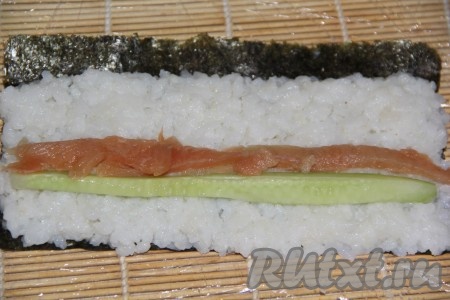 Красную рыбу нарезать на длинные полоски. Вымытый огурец нарезать на длинные брусочки. Выложить на рис брусочек огурца, рядом сделать полоску из кусочков рыбы.&nbsp;
