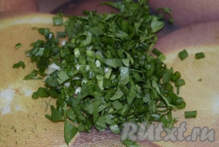 Выложить в суп мелко нарезанные петрушку и зелёный лук.