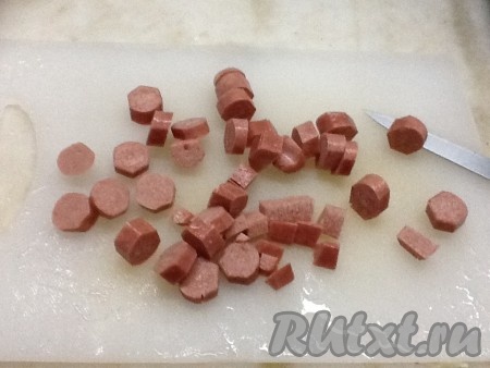 Нарезаем сосиски колечками.