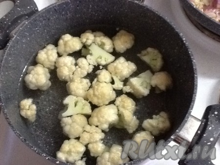 Ставим кастрюлю с водой на огонь. Моем цветную капусту и разрезаем на соцветия. Отправляем в кастрюлю с водой, доводим до кипения, солим, уменьшаем огонь и варим несколько минут, пока обжариваются овощи.