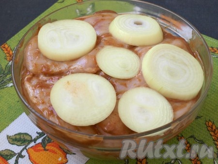 Кольцами нарезать очищенный лук и разместить его между мясом, чтобы он также промариновался. Отправить мясо мариноваться в холодильник на 2-3 часа.