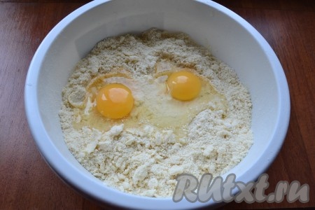 Перетереть получившуюся массу руками до получения мелкой крошки, затем добавить сырые яйца.