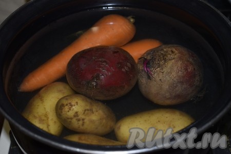 Свеклу, морковь и картофель вымыть и, не очищая овощи, полностью залить водой, поставить на огонь, после закипания воды уменьшить огонь и сварить в мундире (в кожуре) до готовности. Готовность овощей проверяем, прокалывая овощи острым предметом (вилкой, ножом, зубочисткой и т.д.) - сваренные овощи должны прокалываться достаточно легко.