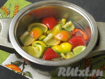 Вскипятить в кастрюле воду, добавить сахар, лавровый лист и уксус, в получившийся маринад выложить половину нарезанного перца, варить на среднем огне 1-2 минуты с момента закипания.
