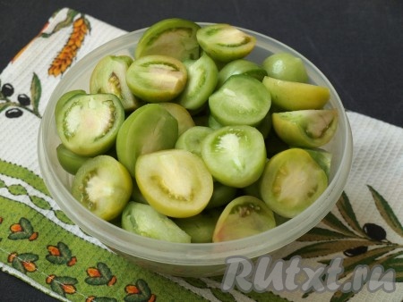 Зелёные помидоры хорошо вымыть, разрезать пополам и вырезать плодоножку.