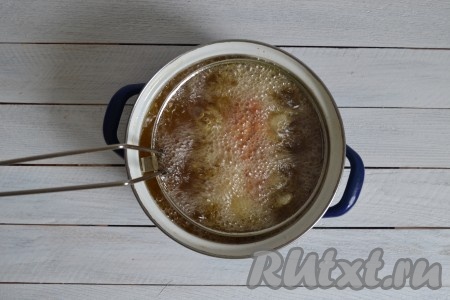 Снизить огонь к минимуму и выложить курицу во фритюр.
