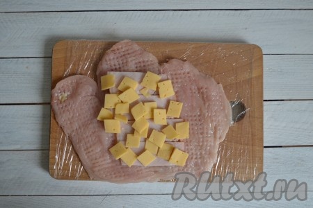 Сверху выложить сыр. Его также необходимо нарезать тонкими ломтиками или натереть на терке.
