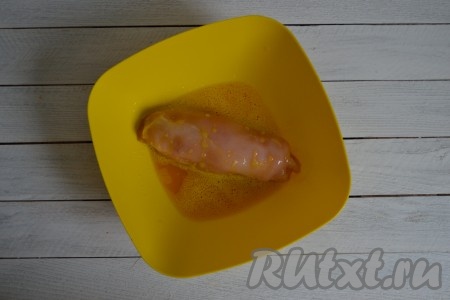 Смочить куриный рулет в яичной массе.
