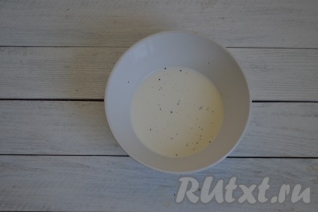 В миску влить 50 мл сливок, добавить по вкусу соль и молотый черный перец, перемешать.

