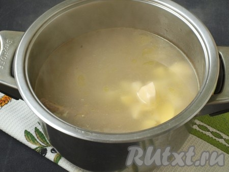 Когда курица будет практически готова, опустить в кастрюлю картофель и варить около 15 минут на небольшом огне.

