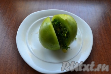 Каждый помидор надрезать пополам не до конца, заполнить разрез подготовленной массой из зелени и чеснока.
