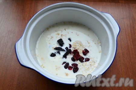 К овсяным хлопьям влить молоко, добавить соль, сахар, ванильный сахар, а также сухофрукты.
