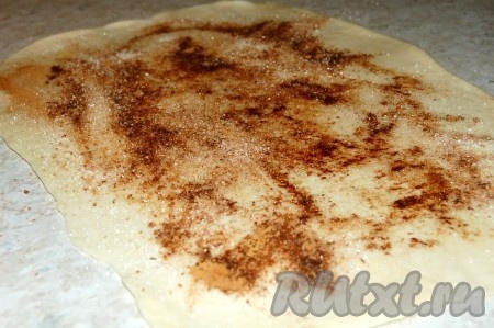 Раскатать его в тонкий пласт, смазать растительным маслом и посыпать всю поверхность сахаром с корицей, отступая от внешних сторон на 1-2 см.