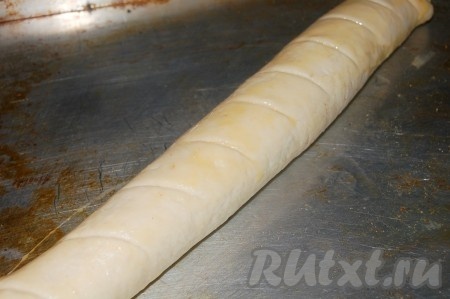 Свернуть дрожжевое тесто рулетом в длину, сделать надрезы.