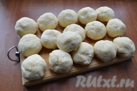Далее добавлять оставшуюся муку, замешивая тесто. Тесто должно быть не слишком тугим, но держащим форму, немного липким. Количество муки зависит от влажности творога, поэтому ее может понадобиться больше или меньше. Из теста сформировать 16 одинаковых шариков.