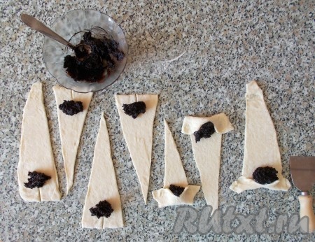 Чайной ложкой выкладываем маковую начинку на широкую сторону каждого получившегося треугольничка. Сворачиваем наши круассаны. Обратите внимание, что для придания круассану красивой формы, на основании каждого треугольничка я делаю надрез (см. фото), чтобы края можно было растянуть в стороны, тем самым удлинив наши круассаны. Если Вы используете какую-то другую начинку (или готовите её сами) – прижмите хорошо уголки теста, чтобы начинка не вытекла. Начинка ТМ SantaVuta Bakers при выпечке зарекомендовала себя очень хорошо - она не вытекает и не расползается. Уже проверено!