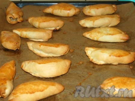 Когда пирожки с капустой из дрожжевого теста буду готовы, вытащить их из духовки, смазать сливочным маслом.