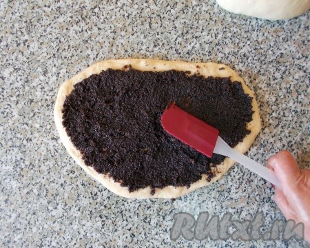 Равномерно распределяем маковую начинку по тесту с помощью силиконовой лопатки (ножа или ложки). Сворачиваем в рулет, плотно прижимая тесто.
