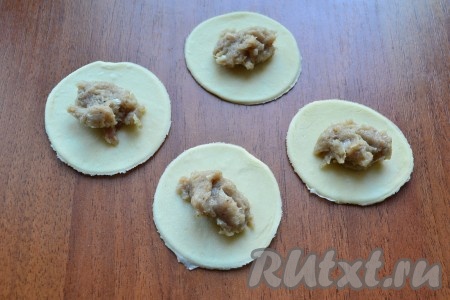 "Отдохнувшее" тесто обмять, раскатать его в лепешку толщиной не более 5 мм, вырезать стаканом кружочки. В центр каждого кружочка поместить по чайной ложке подготовленного фарша.

