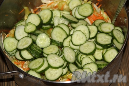 Огурцы вымыть, нарезать кружочками, добавить к капусте, моркови и перцам, хорошо перемешать.
