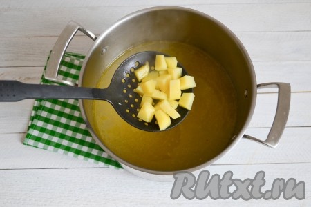 После закипания бульона выложить очищенный и нарезанный на небольшие кубики картофель, довести до кипения, затем огонь уменьшить. Варить картофель 7-10 минут.
