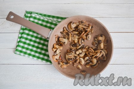 Тщательно вымыть проточной водой шампиньоны, обсушить салфетками и нарезать тонкими пластинами. Разогреть сковороду, влить 1 столовую ложку растительного масла и через минуту выложить грибы. Помешивая, обжарить их на сильном огне до румяности (это займет не более 5 минут).
