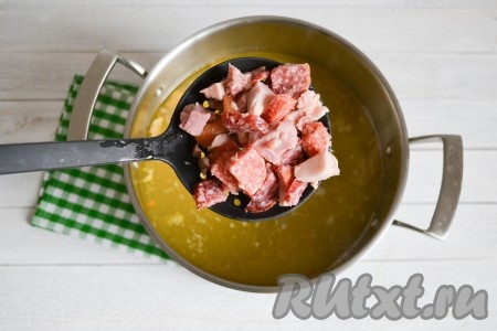 Выложить нарезанную колбасу сразу же за мясом в кастрюлю.
