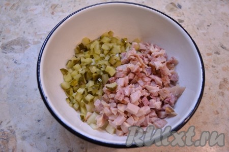 Куриное мясо нарезать маленькими кусочками и добавить к картофелю вместе с нарезанными маленькими кубиками маринованными огурцами.
