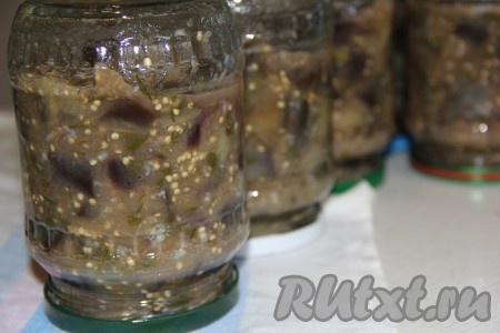 Снять баклажаны с огня и разложить по стерильным банкам. Закрыть банки прокипяченными крышками и перевернуть кверху дном. 