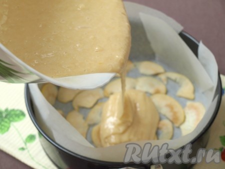 Тесто для шарлотки получится в меру густым (как на фото). Форму застелить пергаментом, на дно выложить половину ломтиков айвы, затем вылить тесто.